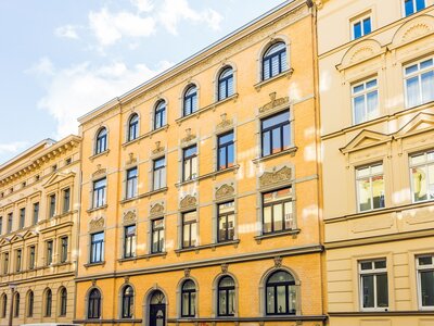Renoviertes Altbau-Wohngebäude mit historischer Fassade bei sonnigem Wetter