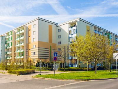 Modernisiertes Wohngebäude mit Grünflächen bei sonnigem Wetter