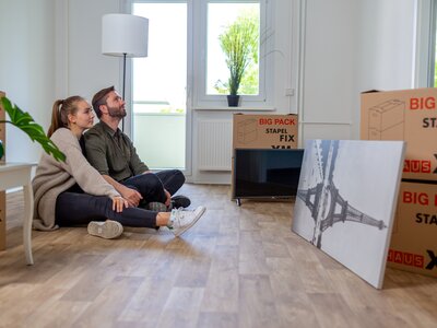 Ein Paar in ihrer neuen Wohnung mit Umzugskartons