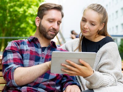 Pärchen schaut sich auf dem Tablet die Wohnung an
