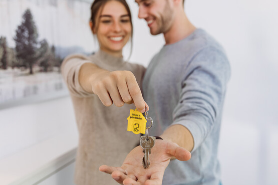 Paar freut sich über den neuen Wohnungsschlüssel