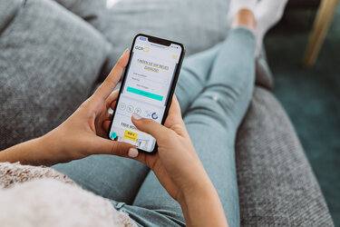 Frau mit Handy in der Hand auf dem die GCP App zu sehen ist