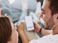 Eine Frau und ein Mann schauen auf ein Handy