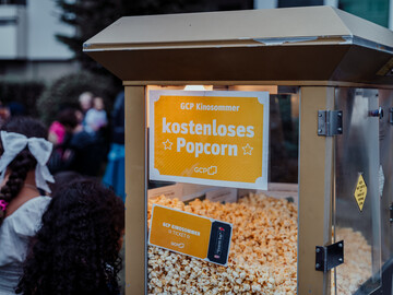 Eine Popcornmaschine mit einem Schild "kostenloses Popcorn"
