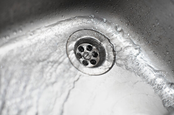 abfluesse-reinigen-gcp-ratgeber.jpg Ansicht eines Abflusses mit fließendem Wasser